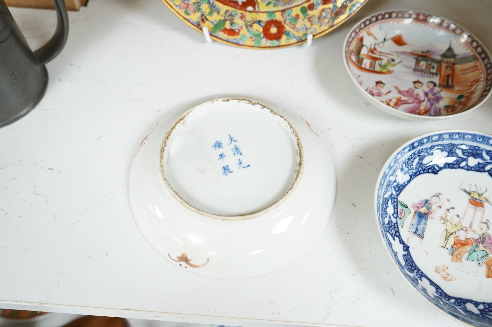 An 18th century Chinese clobbered dish, a famille rose dish, Guangxu six character mark and two 18th century Chinese export saucers, largest 22cm